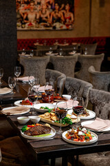 Gourmet dinner in elegance. Tables are set with wine glasses and gourmet meals in a stylish restaurant, creating an inviting atmosphere for dinner.