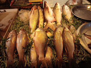 Fototapeta premium Fresh fish and seafood, prepared and raw, available at a bustling market
