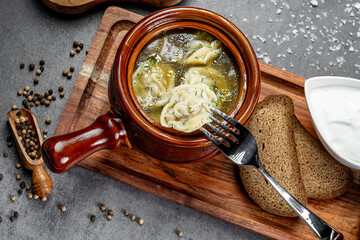 Hot dumplings in rich broth. Delicious dumplings floating in a flavorful broth with herbs, served...
