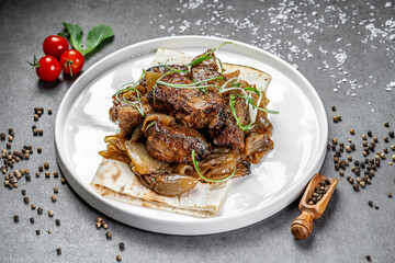 Grilled meat and veggies dish. Tender grilled meat served with sauteed onions on a flatbread,...