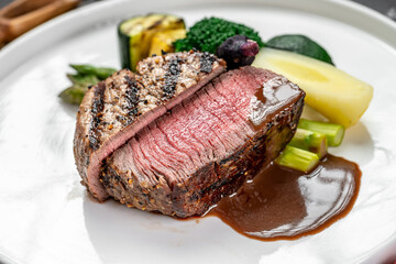 Beef and veggies cooked just right. A succulent slice of beef is plated with grilled vegetables,...