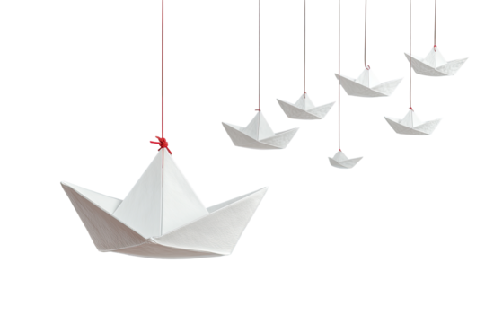Several origami paper boats hanging from strings