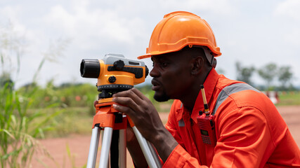 Surveyors and civil engineers using a theodolite and road construction plans to measure and inspect...