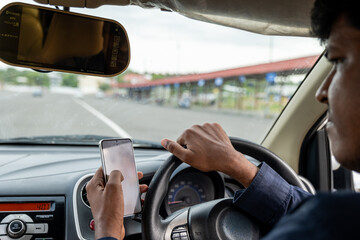 Driver using smartphone while navigating busy road