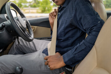 Man fastening seatbelt in car before driving safety