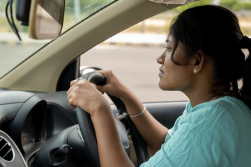 Woman driving a car on a sunny day in the city