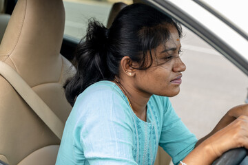 Woman driving a car in a city on a sunny day
