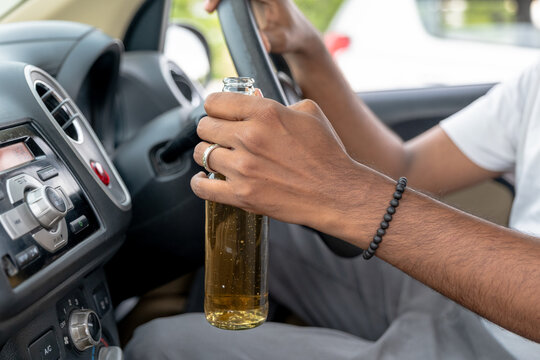Driving with beverage in hand during a summer day