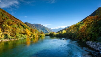 Obraz premium lush green mountains surround serene river creating tranquil landscape filled with vibrant foliage and clear skies