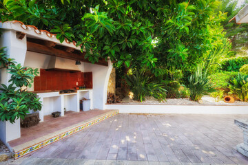 Mediterranean-style barbecue surrounded by a lush garden.