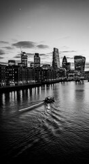 Fototapeta premium London's Skyline at Dusk: Cityscape with Boat on the Thames River