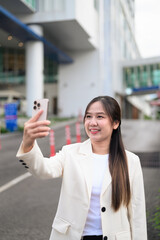 Portrait of happy Southeast Asian businesswoman outdoors in the city street smiling