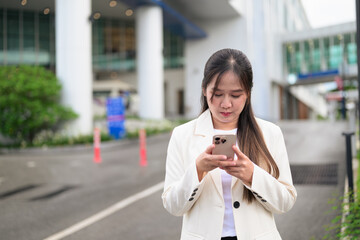 Fototapeta premium Portrait of Southeast Asian businesswoman outdoors in the city street