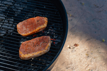 Two Raw Pork Chops Just Placed on the Grill