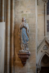 Langrune-Sur-Mer, France - 08 09 2025: Detail view of a statue of the Virgin Mary standing with clasped hands inside the Saint-Martin Church