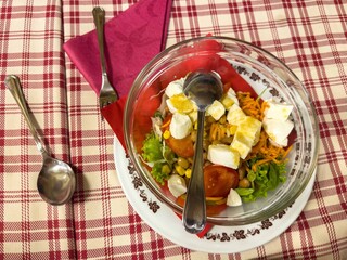 Fresh vegetable salad with feta cheese on checkered tablecloth