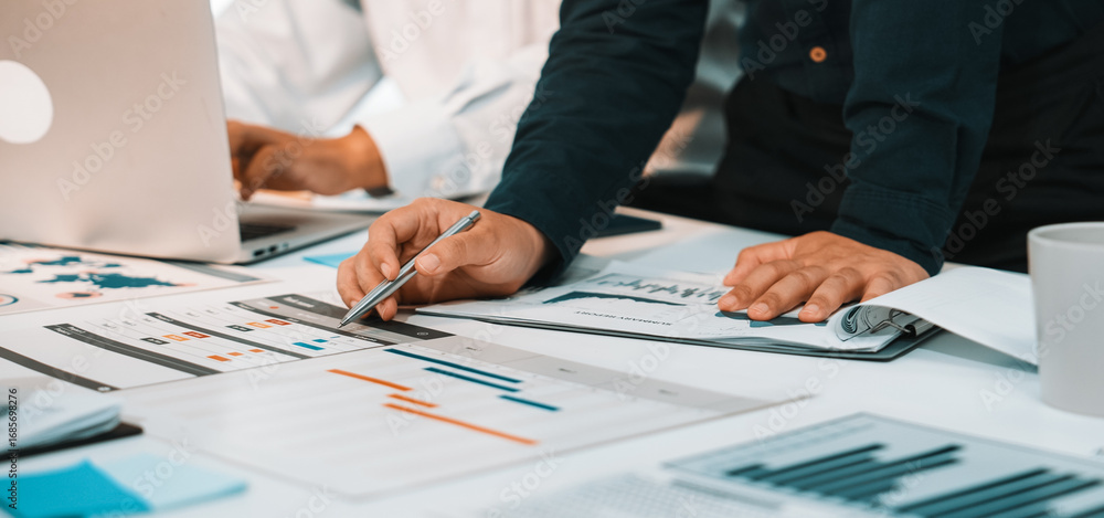 Poster business professionals engaged in a dynamic analysis of financial reports and charts while collabora