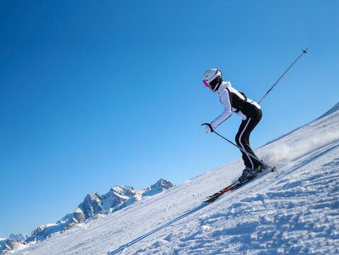 young athletic woman skiing skillfully at ski resort in mountains