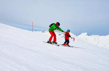 toddler boy confidently skis on his own at a ski resort in the mountains