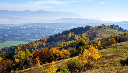 Autumnal hillside overlooking valley with town in the distance, soft lighting