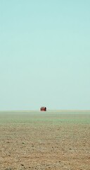 Obraz premium Solitary red house in a vast plain.