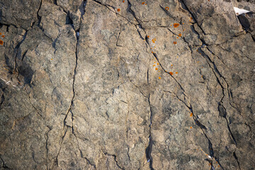 Rock texture. Cracks on the surface of the cliff. Natural stone background.