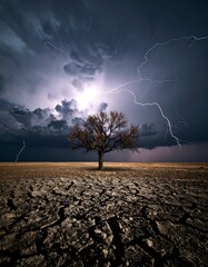 Dramatic storm over cracked earth with lone tree