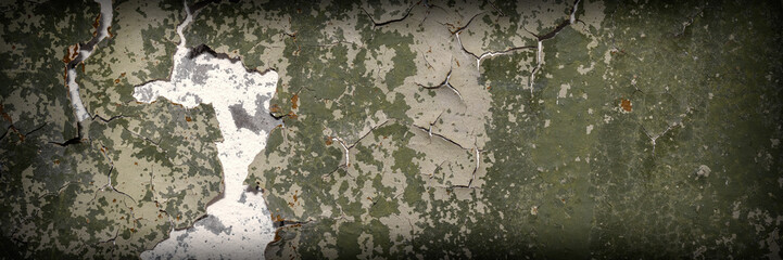 Peeling paint on the wall. Panorama of a concrete wall with old cracked flaking paint. Weathered rough painted surface with patterns of cracks and peeling. Wide panoramic texture for grunge background