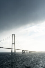 Suspension Bridge Over Ocean Under Dramatic Sky