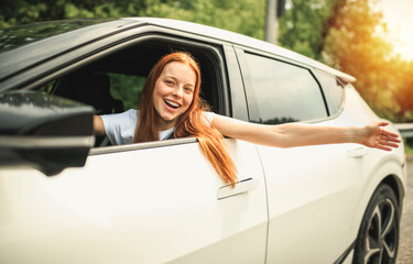 Beautiful young girl driver with with her white car