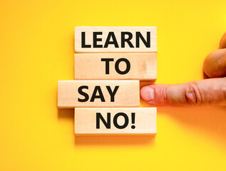 Naklejka premium Learn to say no symbol. Concept words phrase Learn to say no on beautiful wooden blocks. Beautiful yellow paper background. Businessman's hand Business psychological Learn to say no concept Copy space