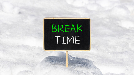 Break time symbol. Concept word Break time on beautiful black blackboard. Beautiful white snow background. White snow. Black blackboard. Business break time concept. Copy space.