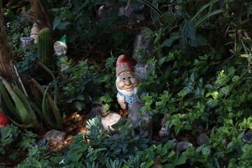 Decorative gnome among plants in the garden