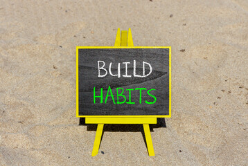Build habits symbol. Concept word Build habits on beautiful black blackboard. Beautiful sand beach...