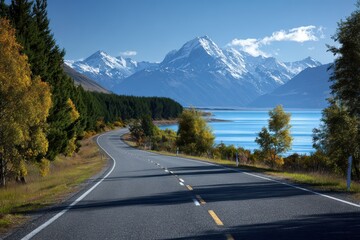 Naklejka premium Stunning road along Lake Pukaki with Mount Cook in the background showcasing vibrant autumn colors and clear blue skies