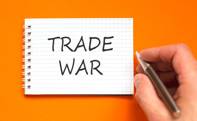 Trade war symbol. Concept word Trade war on beautiful white note. Businessman's hand with pen....