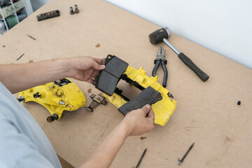 A mechanic replaces worn brake pads while inspecting brake calipers in a well-equipped workshop