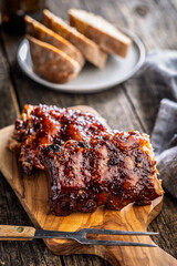 Pork BBQ glazed ribs on wooden cutting board.