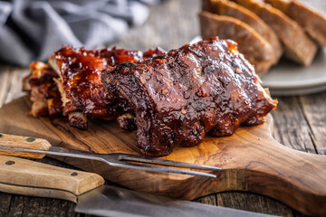 Pork BBQ glazed ribs on wooden cutting board.
