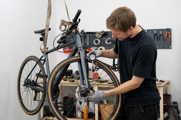 A person is adjusting the tire pressure of a bicycle using a hand-held gauge. The setting is a...