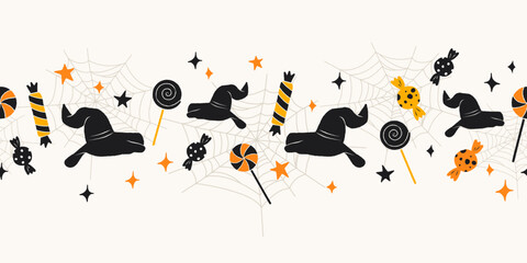 Halloween seamless border with cute witch hats, candies, lollipops, stars, and spider webs on light background. Halloween trick or treat and holiday decoration concept