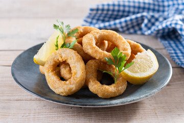 Crispy fried squid rings on wooden table