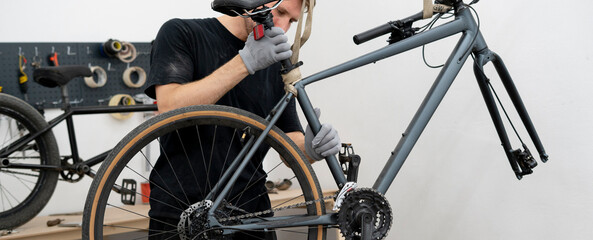 A bicycle mechanic meticulously inspects a bike in a clean workshop, ensuring everything is in...
