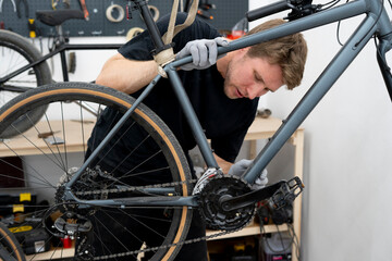 Fototapeta premium A bicycle mechanic meticulously inspects a bike in a clean workshop, ensuring everything is in optimal working condition.
