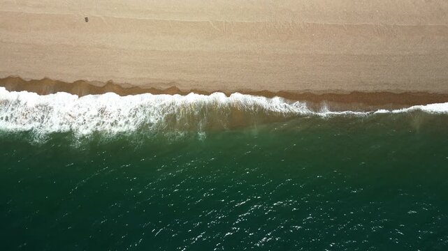 Top Down view of waves crushing the shore at Chesil beach UK