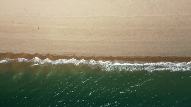 Top Down view of waves crushing the shore at Chesil beach UK