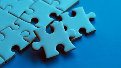 Fototapeta premium Close-up of White Jigsaw Puzzle Pieces on a Blue Background game challenge
