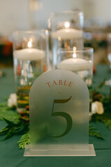 Elegant table number 5 displayed amidst floral arrangements and candles during a festive event