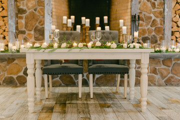 Elegant wedding reception table with candles and floral decorations in a rustic venue setting