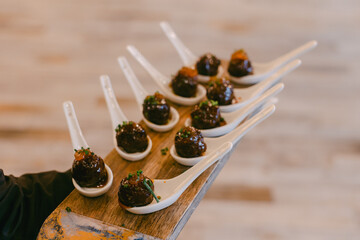 Delicious gourmet appetizers served on elegant spoons at a modern culinary event